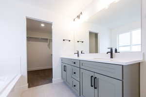 Dual vanity featuring light gray cabinetry with black hardware, white countertops, and matte black fixtures