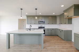 Contemporary kitchen with sage-finished cabinetry and a white subway tile backsplash