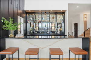 Indoor dry bar featuring recessed lighting and dark stone counters
