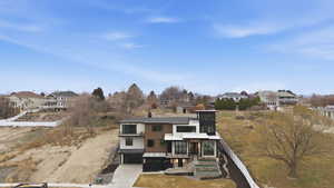 Rear view of property with a residential view, driveway, and an attached garage