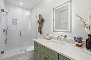 Full bathroom with vanity, a shower stall, and recessed lighting
