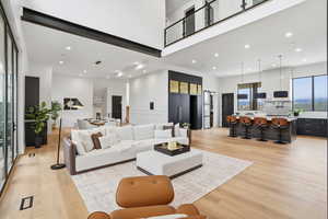 Living area featuring a high ceiling, recessed lighting, and light wood-type flooring