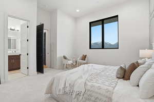 Bedroom featuring light colored carpet, ensuite bath, and recessed lighting