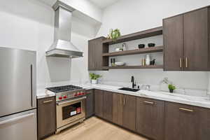 Kitchen with dark wood finish cabinetry, stainless steel appliances, ventilation hood, modern cabinets, and light stone counters