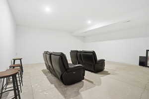 Cinema featuring unfinished concrete floors and baseboards