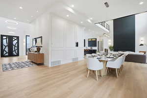 Dining room featuring a high ceiling, light wood-type flooring, and recessed lighting