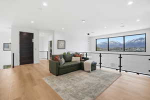 Living area with light wood-type flooring, a mountain view, and recessed lighting