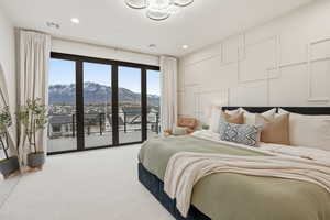 Carpeted bedroom with a mountain view, a decorative wall, access to exterior, and hanging lights
