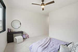Carpeted bedroom featuring ceiling fan and baseboards