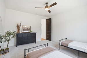 Bedroom featuring ceiling fan and carpet