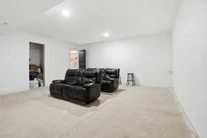 Home theater with concrete flooring and recessed lighting