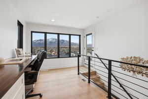 Office area featuring light wood-style flooring, a mountain view, plenty of natural light, and recessed lighting