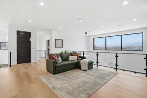 Living area featuring light wood-style flooring and recessed lighting