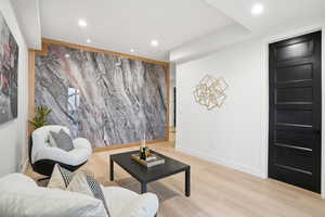 Sitting room with an accent wall, recessed lighting, and light wood finished floors