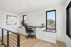 Office area with light wood-style floors, recessed lighting, and built in study area