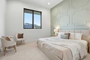 Carpeted bedroom with an accent wall and recessed lighting
