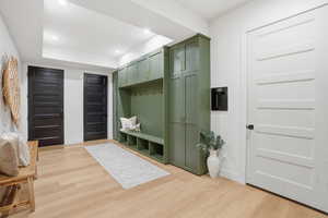 Mudroom with light wood-style floors, a tray ceiling, and recessed lighting