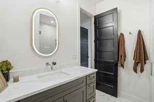 Full bath featuring vanity and light marble finish floors