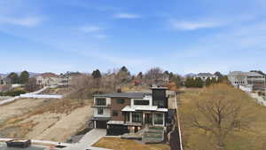 View of front of property featuring a residential view, an attached garage, concrete driveway, solar panels, and a metal roof