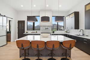 Kitchen featuring a kitchen bar, modern cabinets, tasteful backsplash, a kitchen island, and healthy amount of natural light