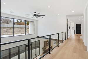 Corridor featuring light wood-type flooring and recessed lighting