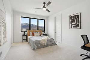 Bedroom with carpet, a ceiling fan, a mountain view, and a desk