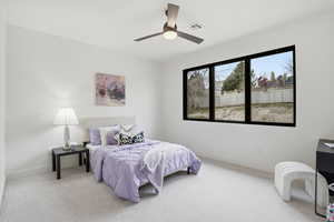 Carpeted bedroom featuring ceiling fan and baseboards