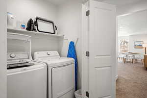 Laundry area featuring carpet, independent washer and dryer, and a textured ceiling