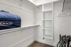 Walk in closet with dark carpet