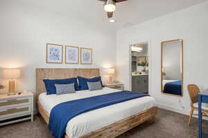 Bedroom with dark carpet, ensuite bathroom, ceiling fan, and recessed lighting