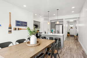 Dining space with light wood finished floors and recessed lighting