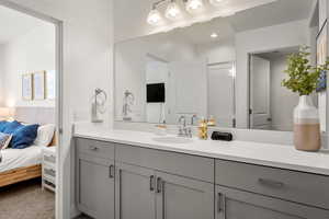 Full bathroom featuring ensuite bath, vanity, and a shower with door