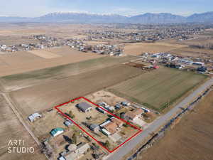 Aerial view of sparsely populated area featuring mountains, property parcel outlined, and nearby suburban area