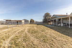 Fenced backyard with a wooden deck, a patio, and an outbuilding