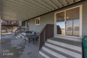 View of patio featuring outdoor dining space and stairs