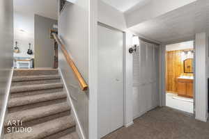 Stairway featuring carpet flooring and a textured ceiling