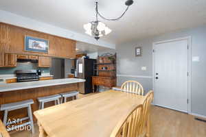 Dining room featuring a textured ceiling, a chandelier, and light wood-type flooring