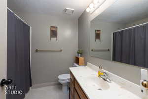 Full bath with a shower with curtain, vanity, a textured ceiling, and light tile patterned floors