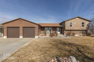 View of front of house with concrete driveway, a front lawn, and a garage