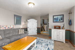 Living area featuring carpet floors and a textured ceiling
