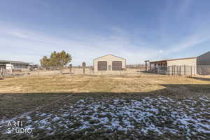 View of yard with an outbuilding, a garage, and a pole building