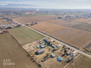 Aerial view of sparsely populated area with a mountainous background and large plots for crops