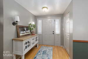 Entryway featuring light wood-style flooring and a textured ceiling