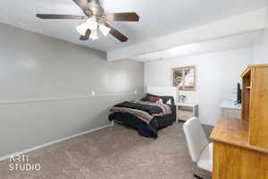 Bedroom with carpet, ceiling fan, and a textured ceiling