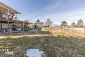 Fenced yard featuring a patio, an outdoor structure, and a deck