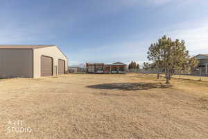 View of yard with an outdoor structure, a detached garage, an outbuilding, and a mountain view
