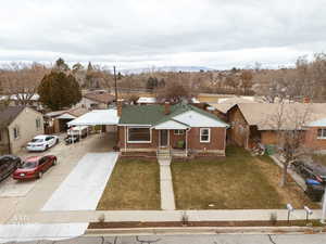 View of front of home featuring new concrete driveway, brick siding, a front lawn, a residential view, and covered porch