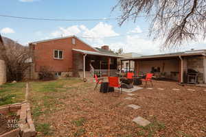 Rear view of property with a patio area and brick siding. Small garden bed for Spring planting!