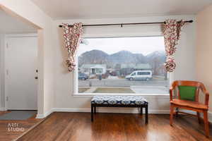 Sitting room featuring a mountain view, wood finished floors, and healthy amount of natural light