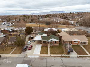 Aerial perspective of suburban area featuring mountains. New concrete driveway and repaired drive approach.